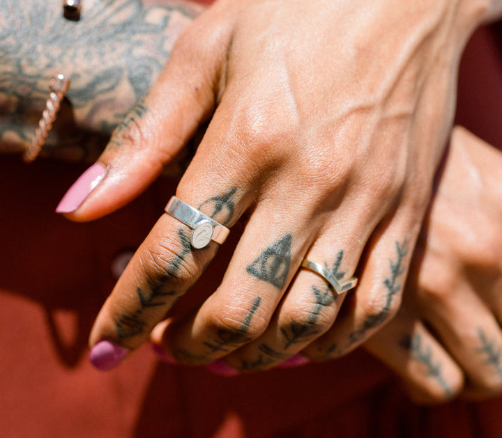 Pictured here is the Oval Crown Cremation Ring design in Sterling Silver by close by me jewelry on a model's index finger