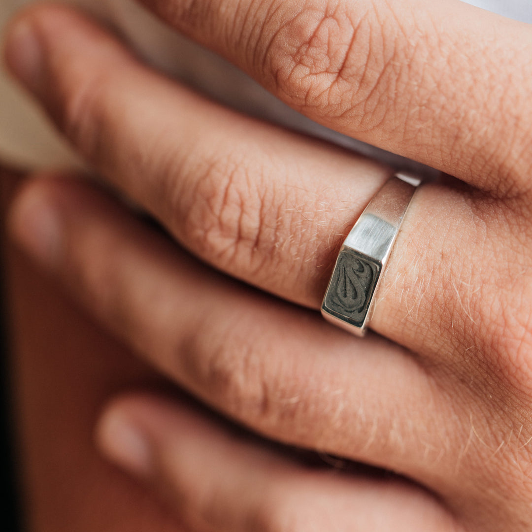 This photo shows a close up of a male model wearing the Sterling Silver Men's Rectangle Signet Ring design by close by me jewelry