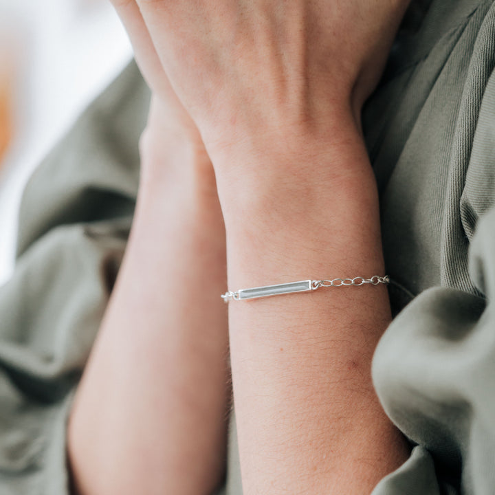 sterling silver cremation thin lateral bar memorial bracelet shown on a model's wrist