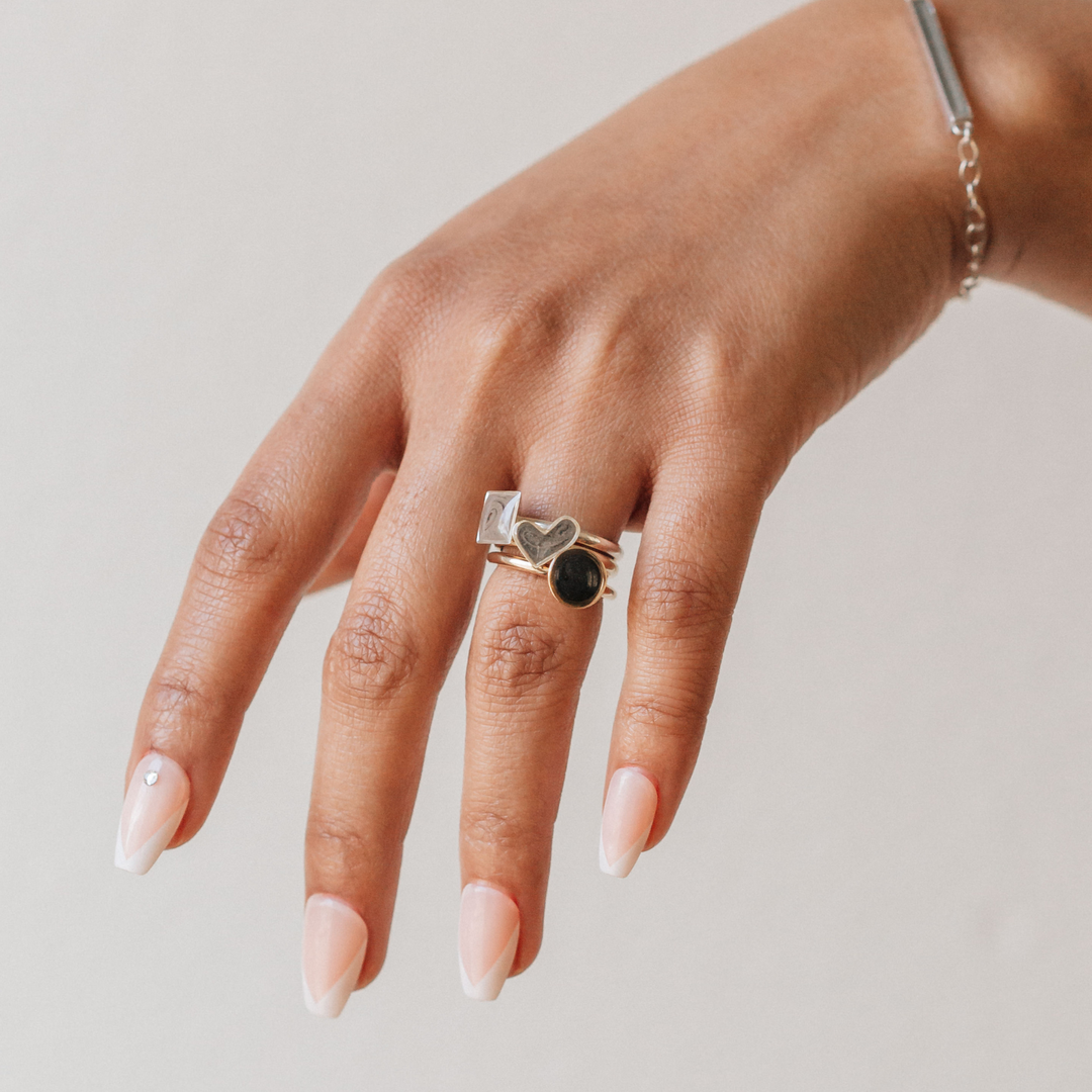 Pictured here is a model wearing close by me jewelry's Mixed Metal Signature Stackable Band Cremains Rings stacked on her ring finger