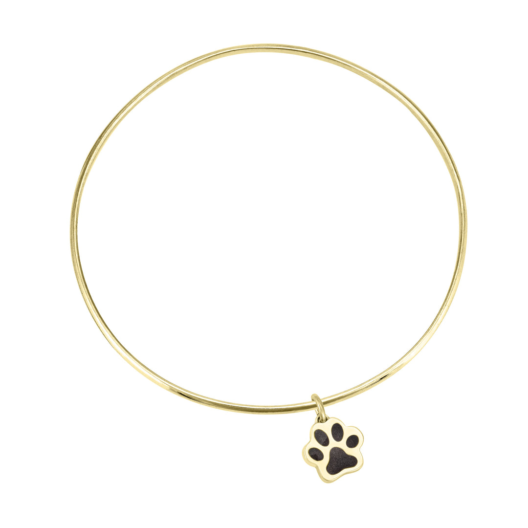 single bangle cremation bracelet in 14k yellow gold with paw print charm shown from the top