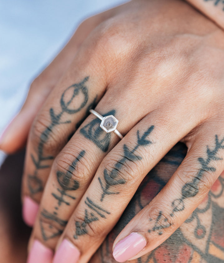 This is a close up photo of the Small Hexagon Stacking Cremation Ring in Sterling Silver designed by close by me jewelry on a model's middle finger