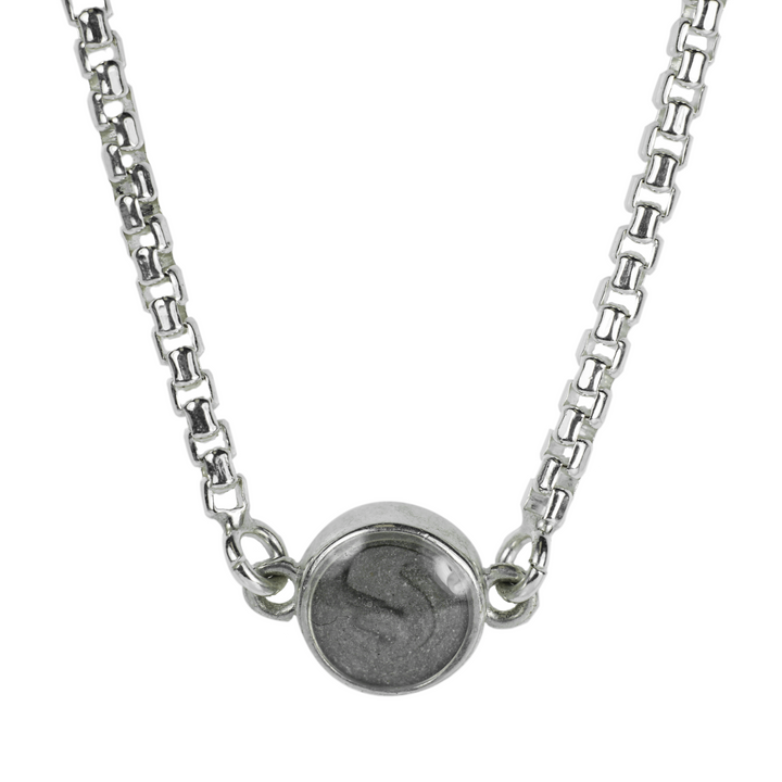 A close up photo of the charm that holds solidified ashes in the Sterling Silver bolo chain bracelet