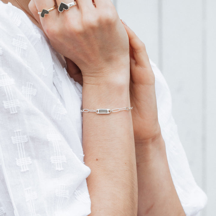 Sterling Silver Chain Link Bracelet shown on the arm of a model holding her hands up to her face