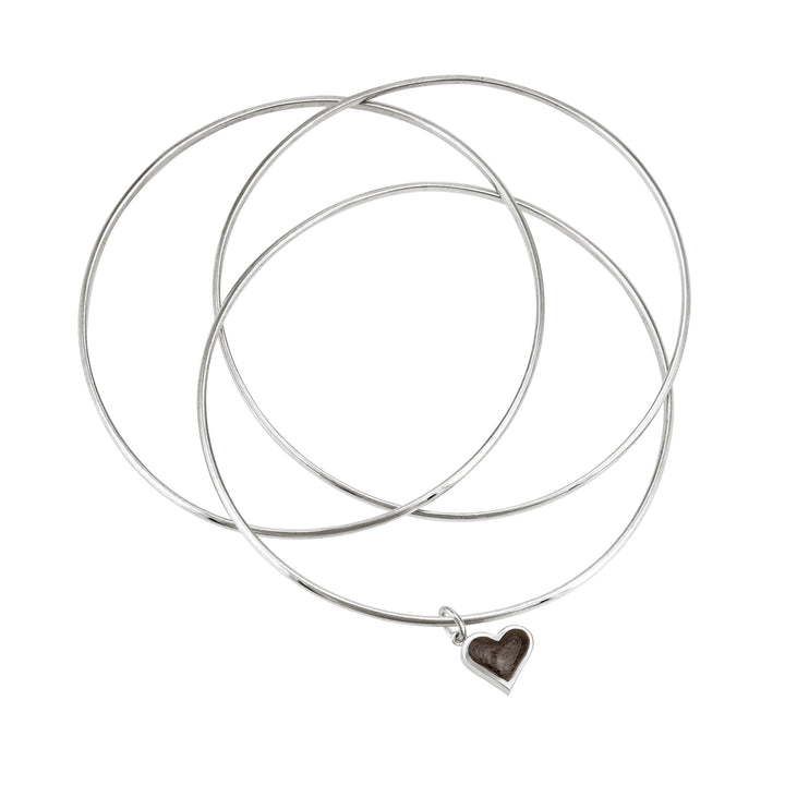 Sterling silver interlocking bangle cremation bracelet with a dainty heart ashes charm, shown from the top