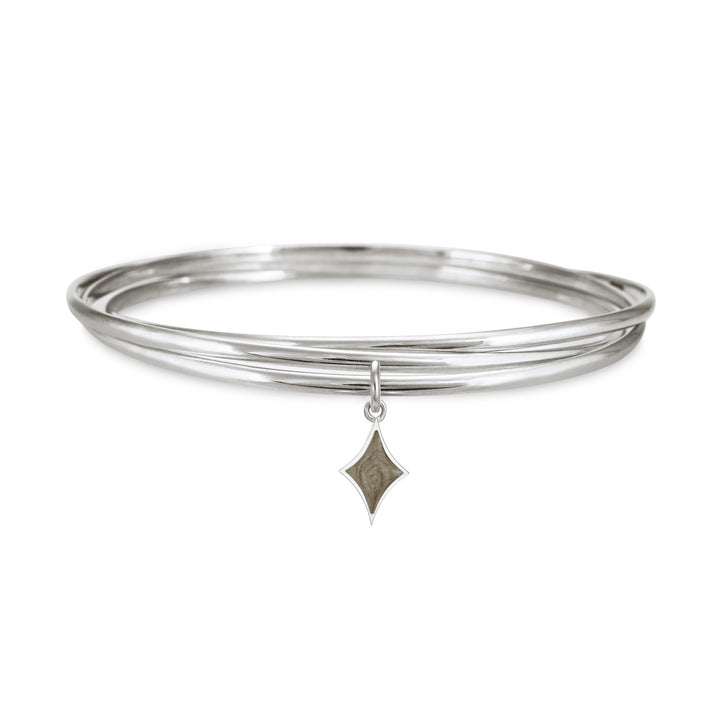 Sterling silver interlocking bangle cremation bracelet with a diamond ashes charm, shown from the front