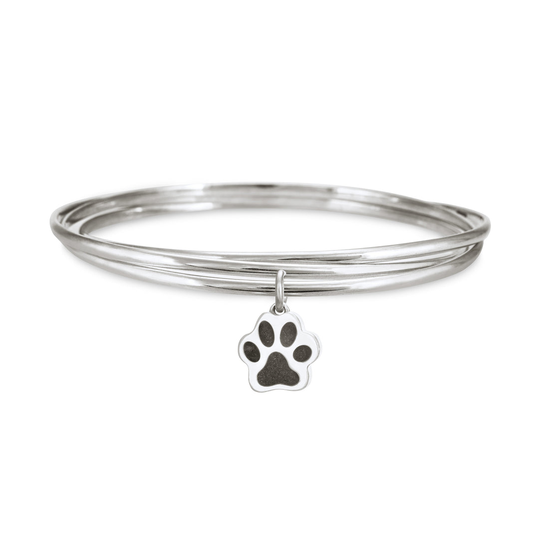 Sterling silver interlocking bangle cremation bracelet with a paw print ashes charm, shown from the front