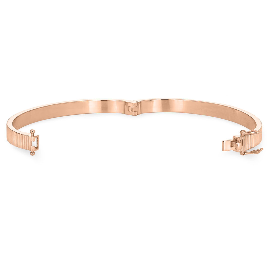 Close By Me's Tessa Bangle Cremation Bracelet in 14K Rose Gold lays flat and turned to the left in an open position against a solid white backdrop.