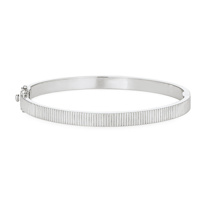 Close By Me's Tessa Bangle Cremation Bracelet in Rhodium Plated Sterling Silver lays flat and in a closed position with the cremation setting on the side facing away from the camera against a solid white backdrop.