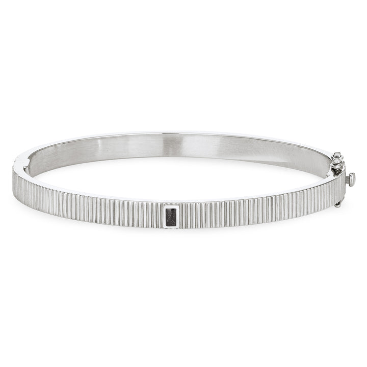 Close By Me's Tessa Bangle Cremation Bracelet in Rhodium Plated Sterling Silver lays flat and facing forward in a closed position against a solid white backdrop.