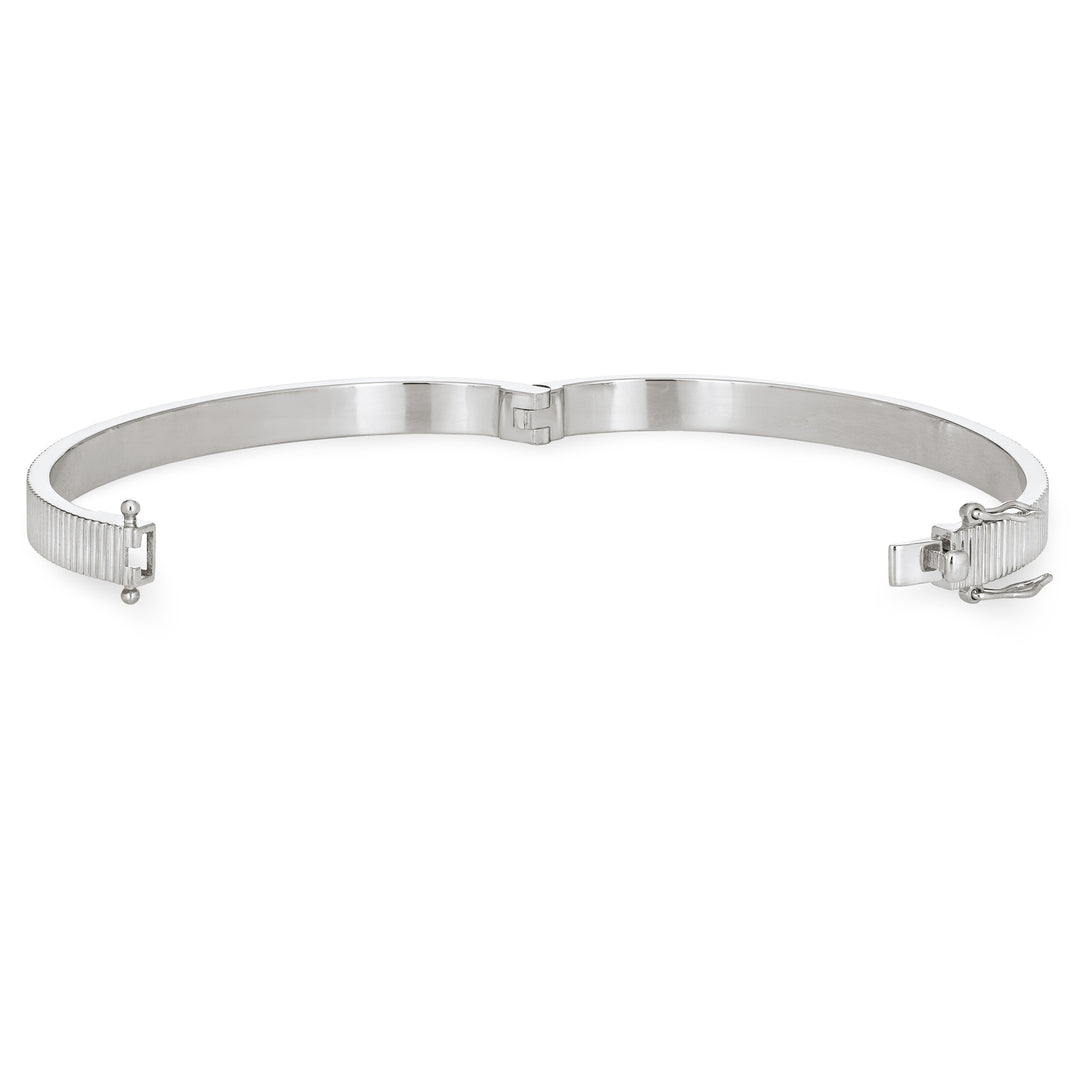 Close By Me's Tessa Bangle Cremation Bracelet in Rhodium Plated Sterling Silver lays flat and turned to the left in an open position against a solid white backdrop.