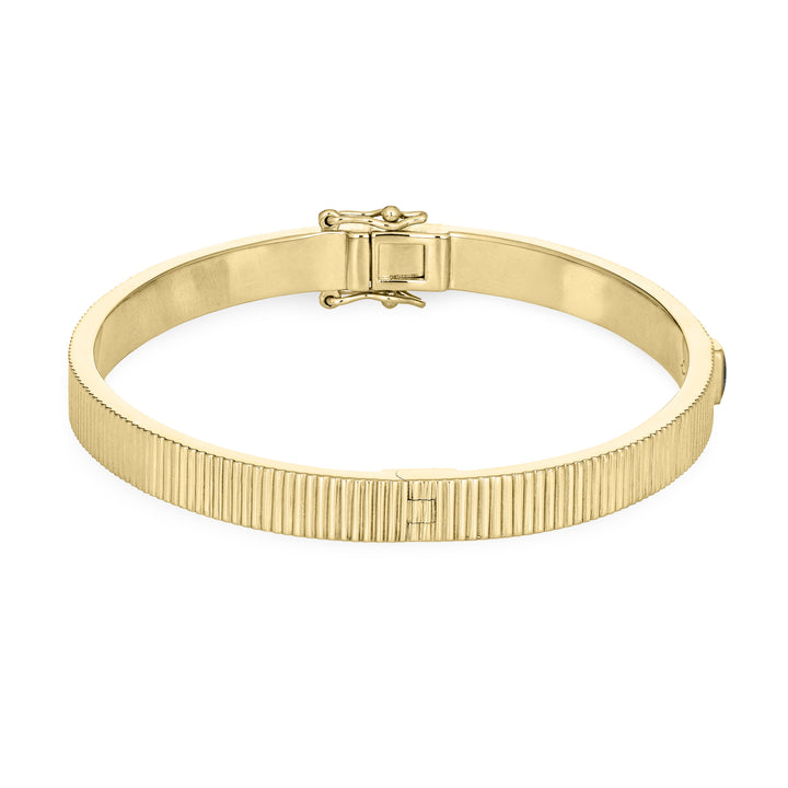 Close By Me's Tessa Bangle Cremation Bracelet in 14K Yellow Gold lays flat and turned to the right in a closed position against a solid white backdrop.