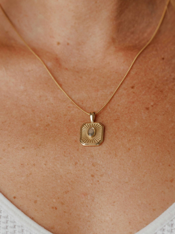 close by me's tessa cremation pendant with oval ashes setting in 14k yellow gold on model