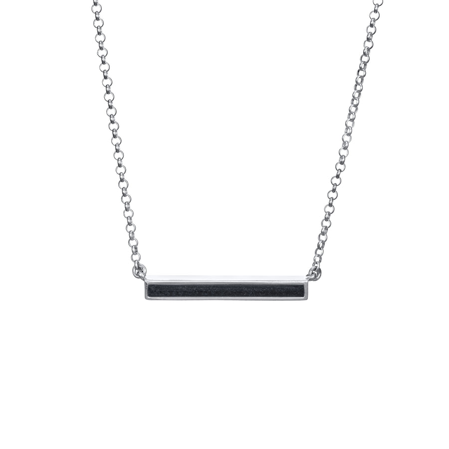 A white gold memorial necklace with an attached chain in a thin lateral bar design showing ashes