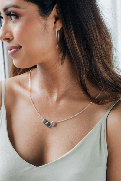 The Sterling Silver Three Setting Chevron Memorial Necklace designed by close by me jewelry being worn by a tan dark-haired model in a light green gown