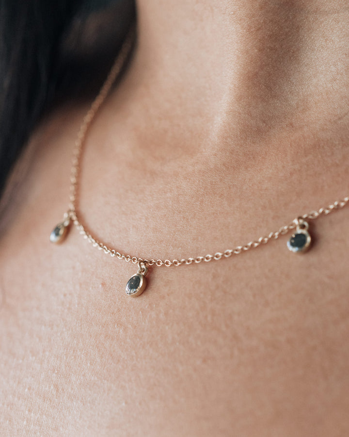 a close up angled photo of a model wearing a cremation necklace