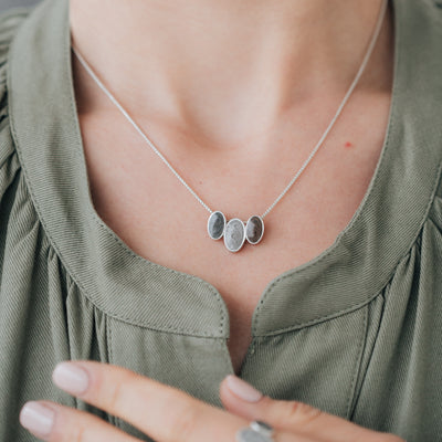 close by me jewelry's Triple Oval Setting Cremation Necklace in Sterling Silver being worn around a model's neck