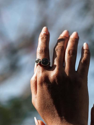 Pictured here is a model wearing two stacking rings with ashes together on her index finger; Designed by close by me jewelry, the 8mm and 12mm Circle Cremated Remains Stacking Rings in Sterling Silver