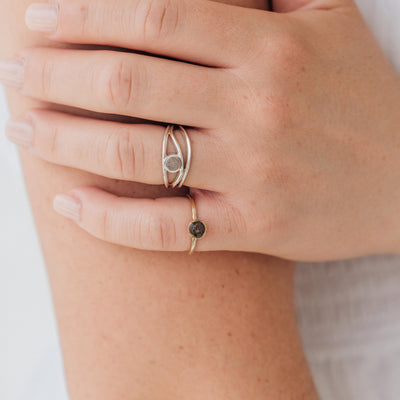 Pictured here are several cremation rings by close by me jewelry on a model's fingers. She wears the 14K Rose Gold 5mm Circle Stacking Ring on her pinky.