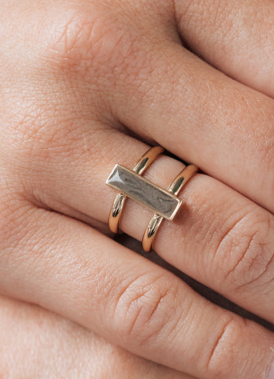 This photo shows a model wearing close by me jewelry's 14K Yellow Gold Bar Ashes Ring on her middle finger
