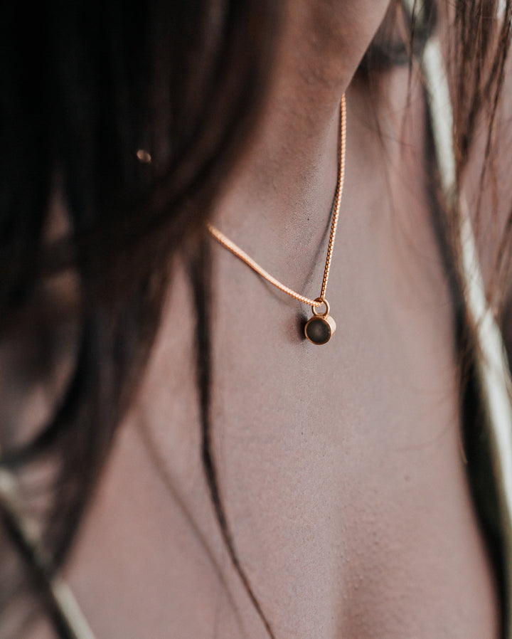 Pictured here is the 14K Rose Gold Bilateral Necklace with ashes, designed by close by me jewelry around a model's neck