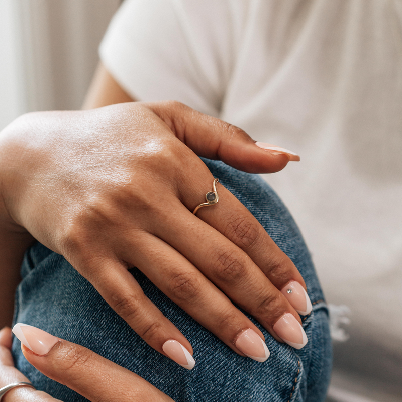 This picture shows a model wearing the 14K Yellow Gold Chevron Circle Ring on her index finger