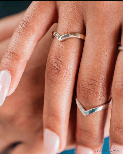 This is a close up photo showing the Chevron Companion Stacking Ring in Sterling Silver as a midi ring on a model's middle finger