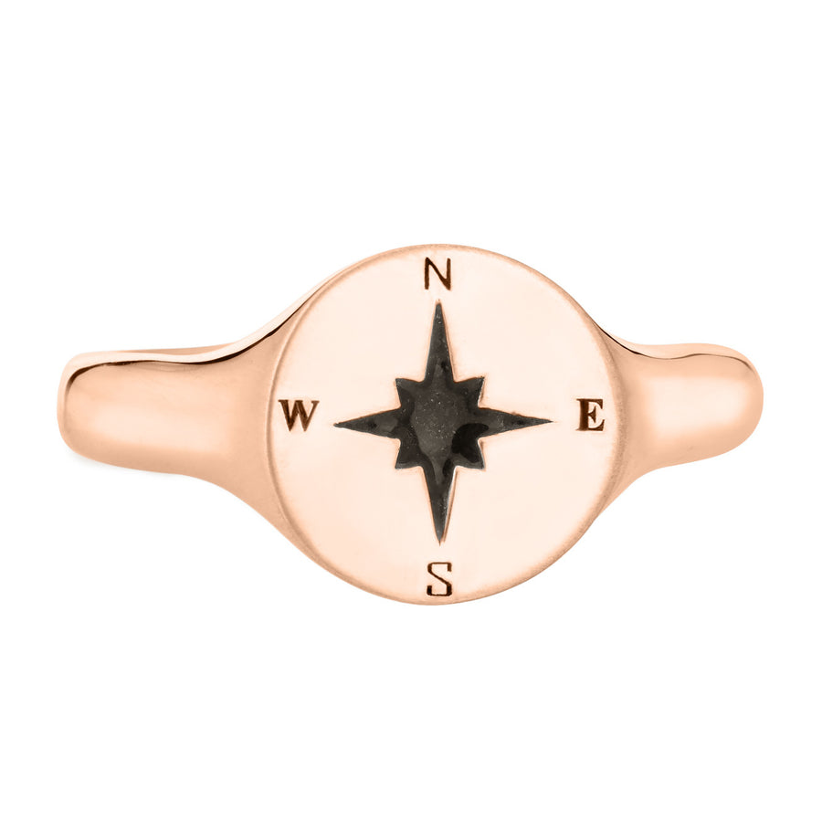Pictured here is the Men's Compass Signet Cremation Ring design by close by me jewelry in 14K Rose Gold from the front. The face of this ring is round with a Compass-Rose Motif and a dark ashes setting.