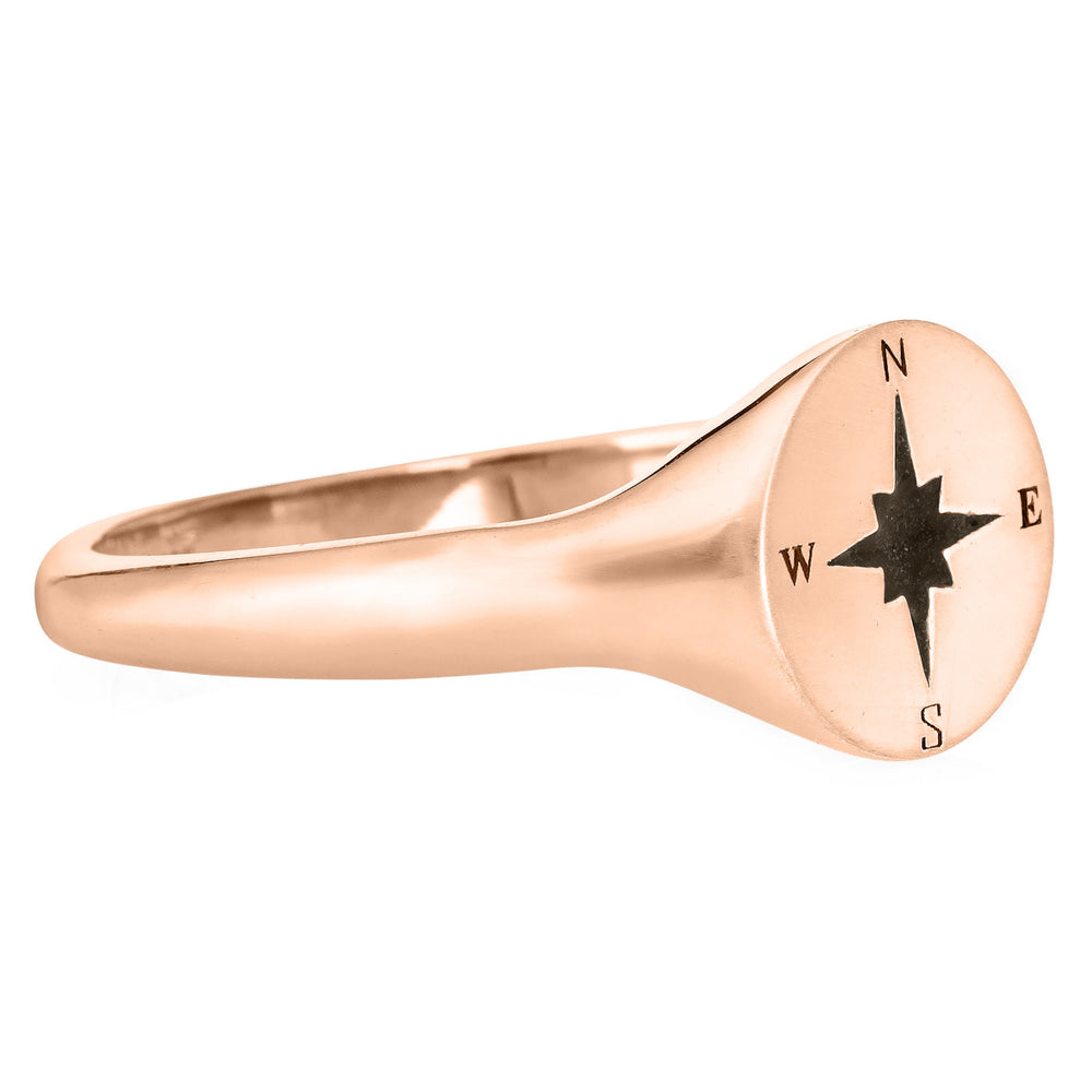 Pictured here is the Men's Compass Signet Cremation Ring design by close by me jewelry in 14K Rose Gold from the side. The face of this ring is round with a Compass-Rose Motif and a dark ashes setting.