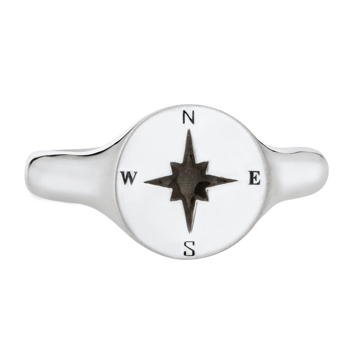 Pictured here is the Men's Compass Signet Cremation Ring design by close by me jewelry in 14K White Gold from the front. The face of this ring is round with a Compass-Rose Motif and a dark ashes setting.