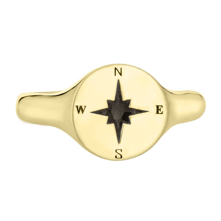 Pictured here is the Men's Compass Signet Cremation Ring design by close by me jewelry in 14K Yellow Gold from the front. The face of this ring is round with a Compass-Rose Motif and a dark ashes setting.
