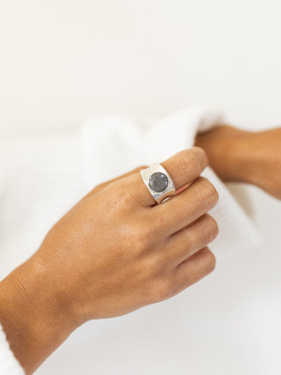 This is a photo of the Concave Band Cremains Ring design in Sterling Silver, made by close by me jewelry, on a model's index finger