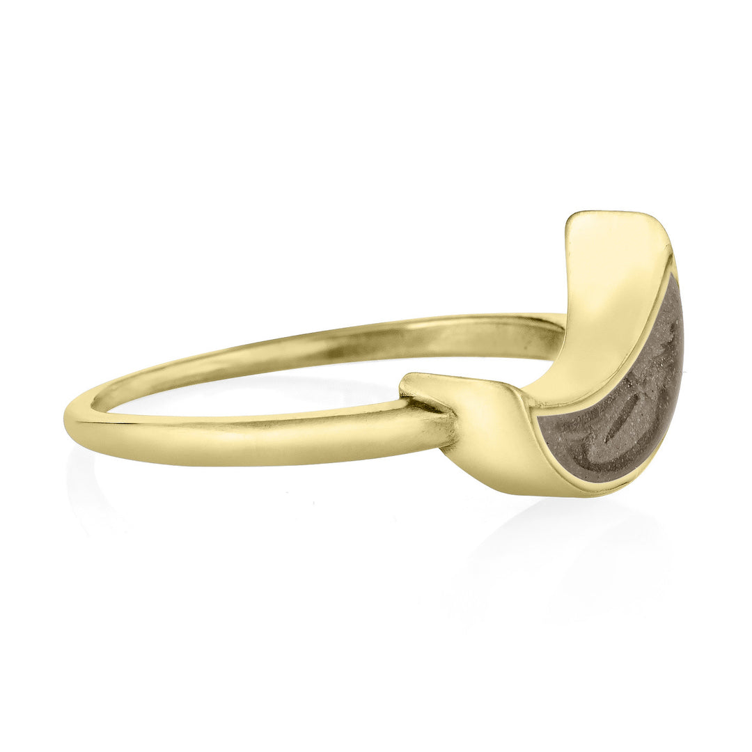 Pictured here is close by me jewelry's 14K Yellow Gold Crescent Moon Ashes Ring from the side to show the thickness of its bezel and its light brown cremation setting