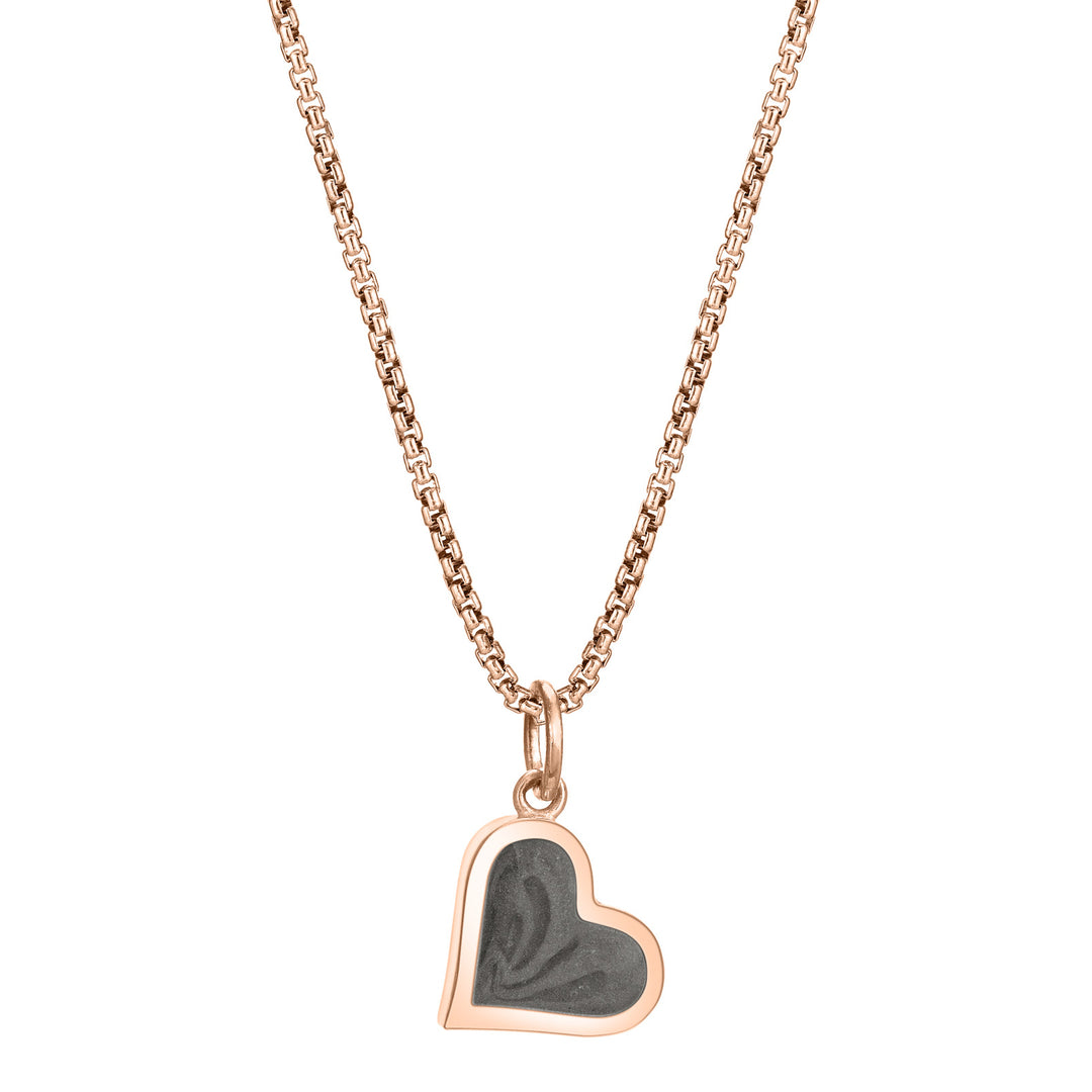 This photo shows the Dainty Heart Ashes Charm designed in 14K Rose Gold by close by me jewelry on a chain from the front