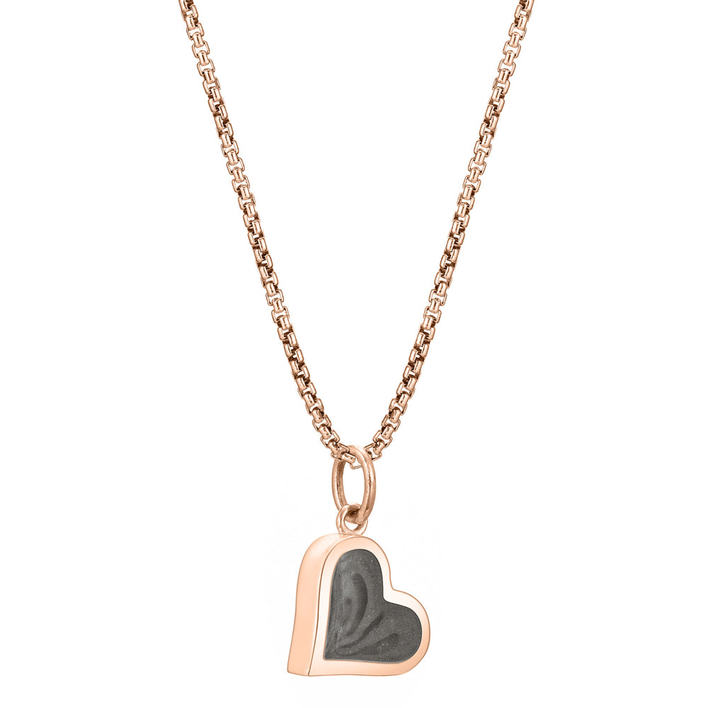 This photo shows the Dainty Heart Ashes Charm designed in 14K Rose Gold by close by me jewelry on a chain from the side