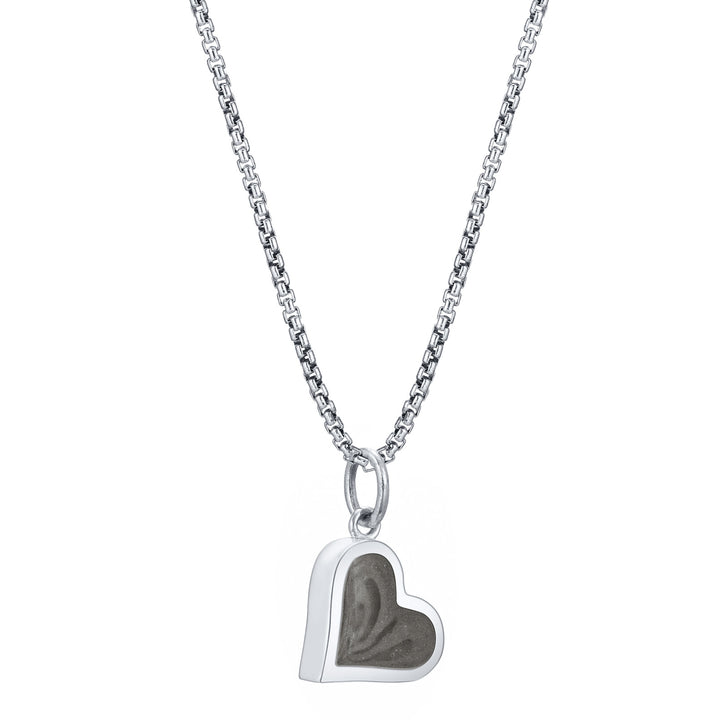 This photo shows the Dainty Heart Charm with ashes designed in 14K White Gold by close by me jewelry on a chain from the side