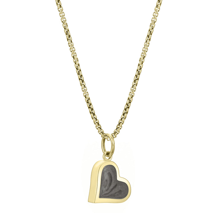 This photo shows the Dainty Heart Cremated Remains Charm designed in 14K Yellow Gold by close by me jewelry on a chain from the side