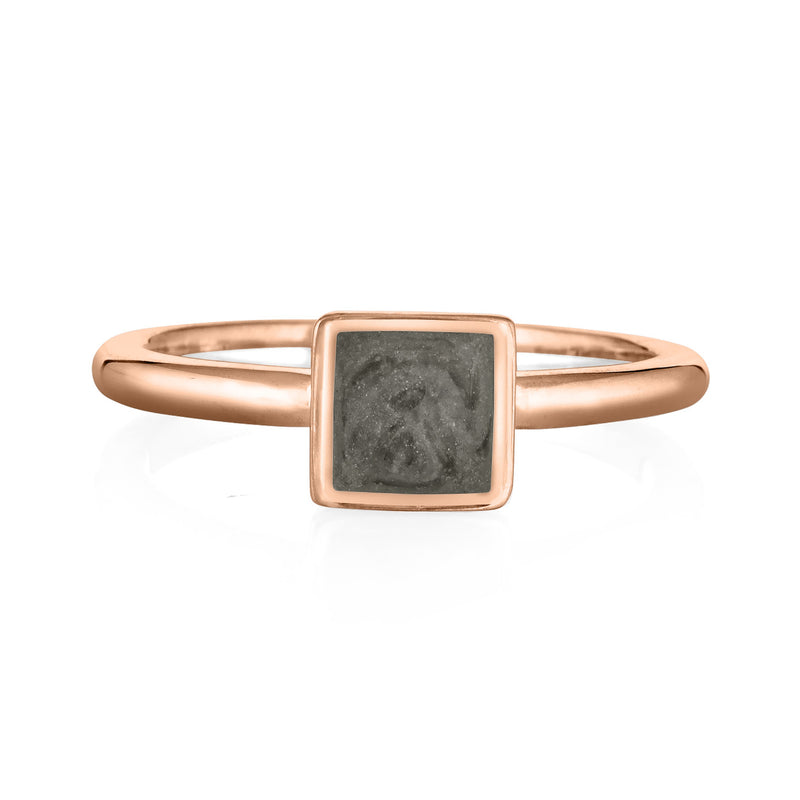 Pictured here is the Dainty Square Cremation Ring in 14K Rose Gold from the front to show its medium gray ashes setting