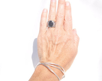 This photo shows the Sterling Silver Floral Art Deco Band Ring on the ring finger of a model's left hand