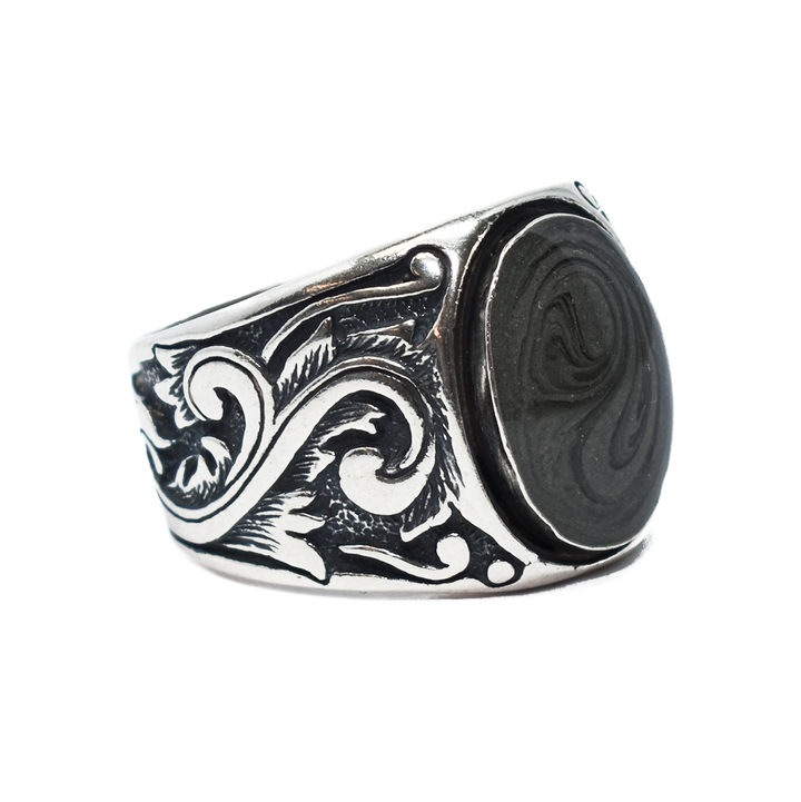 Pictured here is the close by me jewelry's Floral Art Deco Band Cremation Ring in Sterling Silver from the side to show its dark grey cremation setting and filigree detail along the band