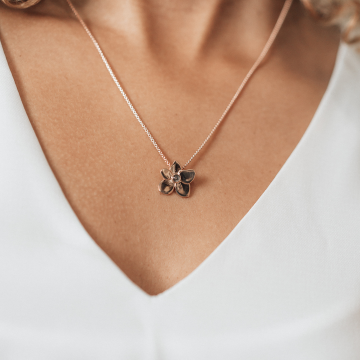 This photo shows a model wearing close by me jewelry's 14K Rose Gold Hydrangea Flower Cremated Remains Pendant 