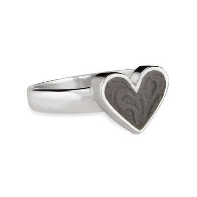 Pictured here is close by me jewelry's Imprint Heart Cremation Ring design in Sterling Silver from the side to show its dark grey ashes setting and thickness of its bezel
