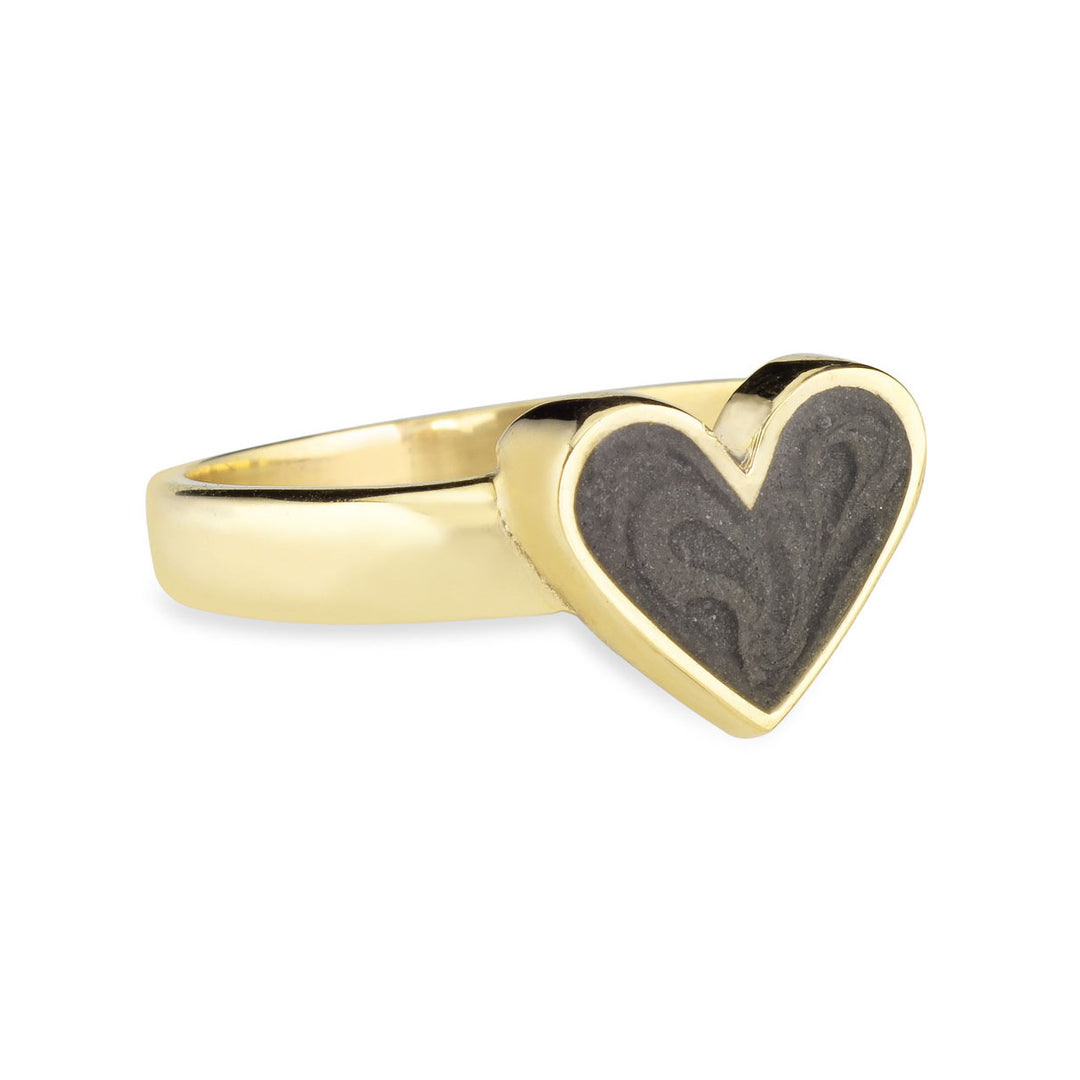 Pictured here is close by me jewelry's 14K Yellow Gold Imprint Heart Cremation Ring design from the side to show its dark grey cremation setting and thickness of its bezel