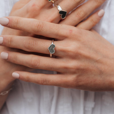 This photo shows a model wearing the Large Heart Stacking Ring in Sterling Silver with other Heart Rings in the background by close by me jewelry
