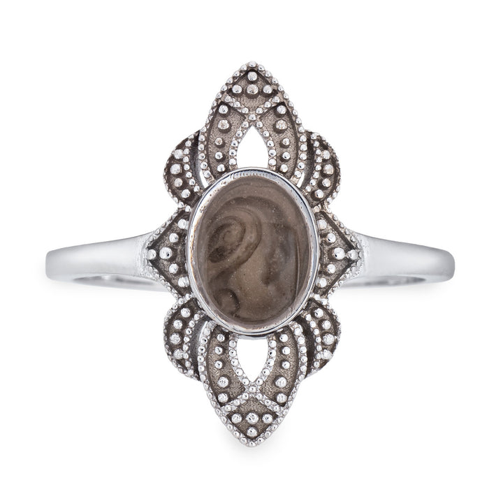 Pictured here is a close-up front view of Close By Me Jewelry's vintage-style World War II Cremation Ring in 14K White Gold set against a solid white background. This version of the ring has a larger oval bezel containing solidified cremated remains. The ashes setting in this photo is medium gray in color and features a distinct swirl pattern.