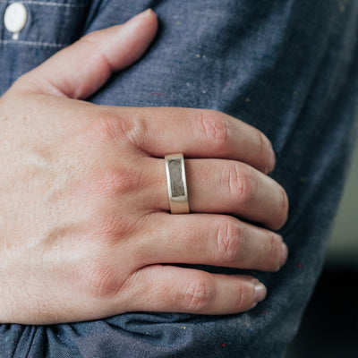 This photo shows a model wearing close by me jewelry's Sterling Silver Men's Classic Band Ashes Ring on their middle finger