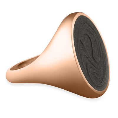 Pictured here is close by me jewelry's Men's Oval Signet Cremation Ring in 14K Rose Gold from the side to show its grey ashes setting and how the tapered band blends into the setting