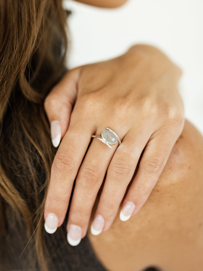 This photo shows a model wearing the Oval Spiral Band Ashes Ring design in Sterling Silver by close by me jewelry