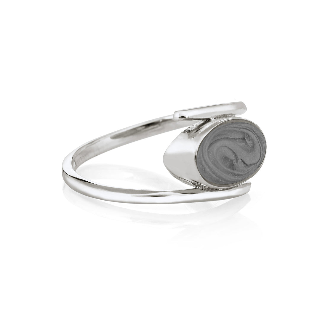 This photo shows the Oval Spiral Band Ashes Ring design in Sterling Silver by close by me jewelry from the side to show its medium gray cremation setting and the thickness of its bezel