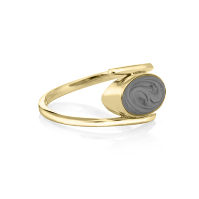 This photo shows the 14K Yellow Gold Oval Spiral Band Ashes Ring design by close by me jewelry from the side to showcase its medium gray cremation setting and thickness of the bezel